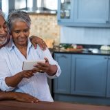 Couple using mobile phone in kitchen