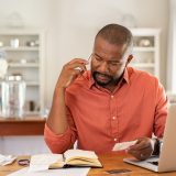 Worried man with bills call the bank